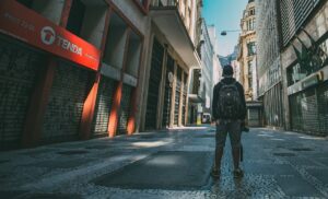 a man standing in the middle of an empty street in an urban area